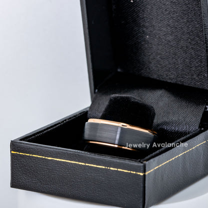Black and rose gold ring in a black jewelry box on a light gray background